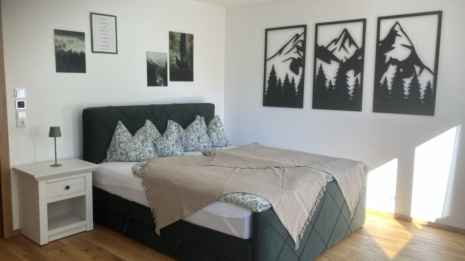 An inviting double room in the bed and breakfast featuring a comfortable box spring bed, stylish wall art, and bright wooden flooring.