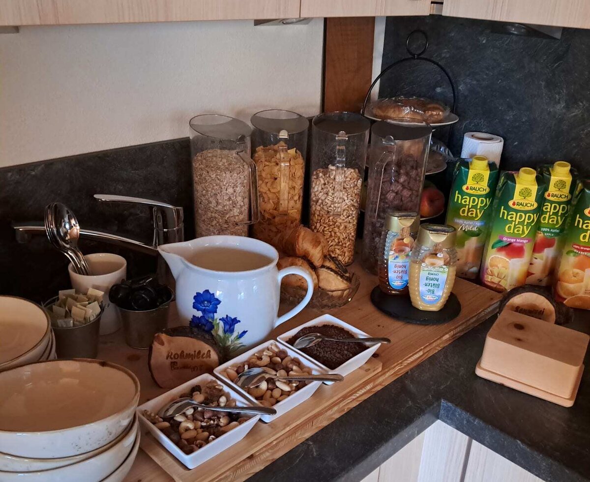 The farmhouse's inviting breakfast buffet featuring muesli, nuts, fresh milk, and a selection of juices.