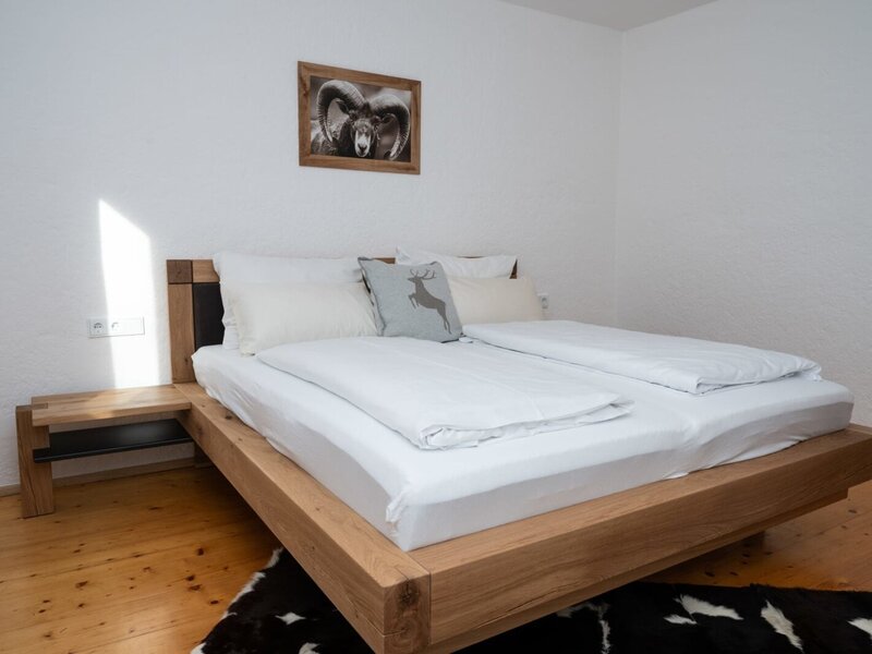 Bedroom in the Apartment featuring a wooden double bed, integrated bedside table, and wooden flooring.