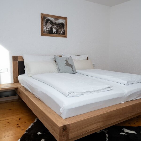Bedroom in the Apartment featuring a wooden double bed, integrated bedside table, and wooden flooring.