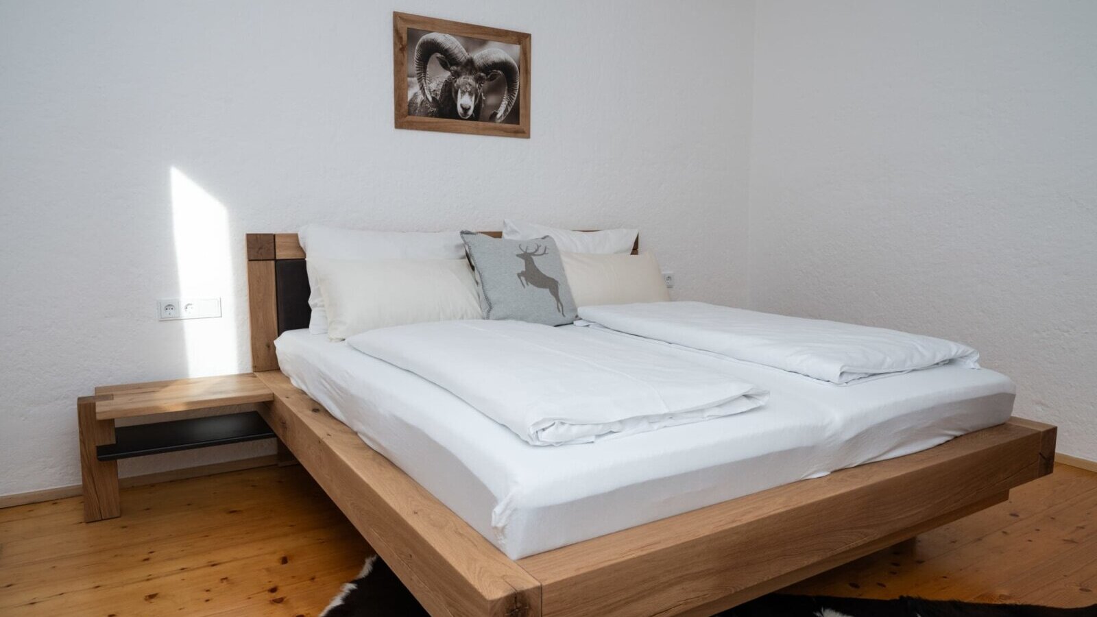Bedroom in the Apartment featuring a wooden double bed, integrated bedside table, and wooden flooring.