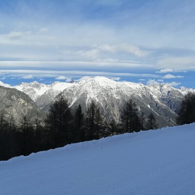 Winter view of the snow-covered mountains and a ski slope from the farmhouse.