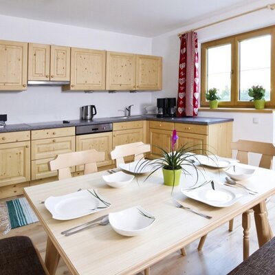 Solid spruce fitted kitchen with electric cooker, refrigerator, oven, microwave, coffee maker, toaster, dishwasher, kettle, slicer, plenty of crockery and glasses.