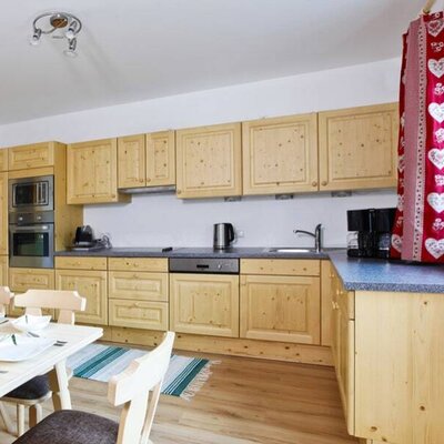 The farm house kitchen features wooden cabinetry, an oven, microwave, dishwasher, and an adjacent dining area.
