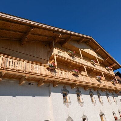 The wooden balconies of the farmhouse, adorned with flower boxes.