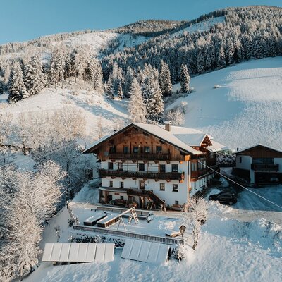 The farmhouse in a snowy mountain landscape with a children's playground.