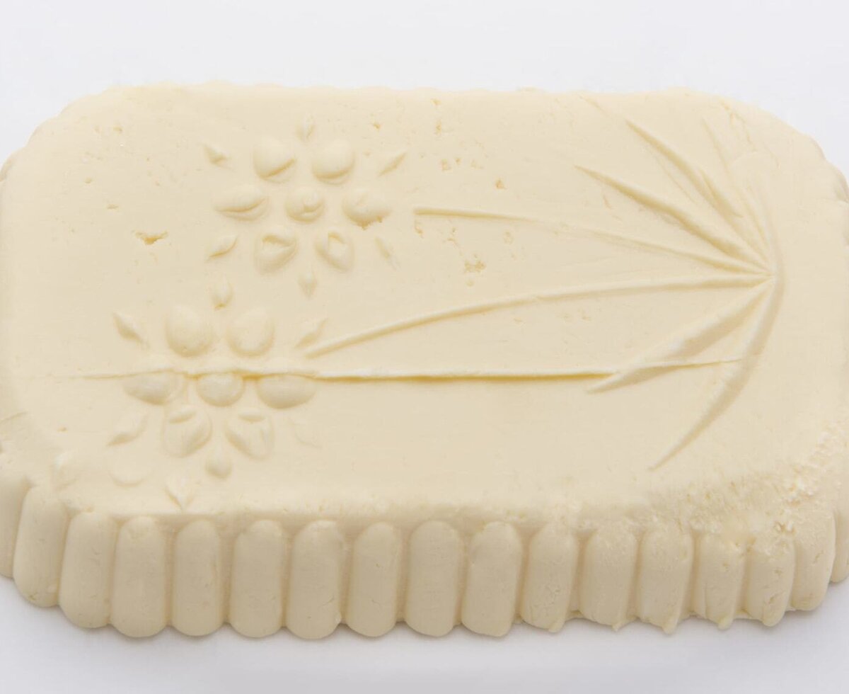 A block of fresh farm butter with decorative patterns.