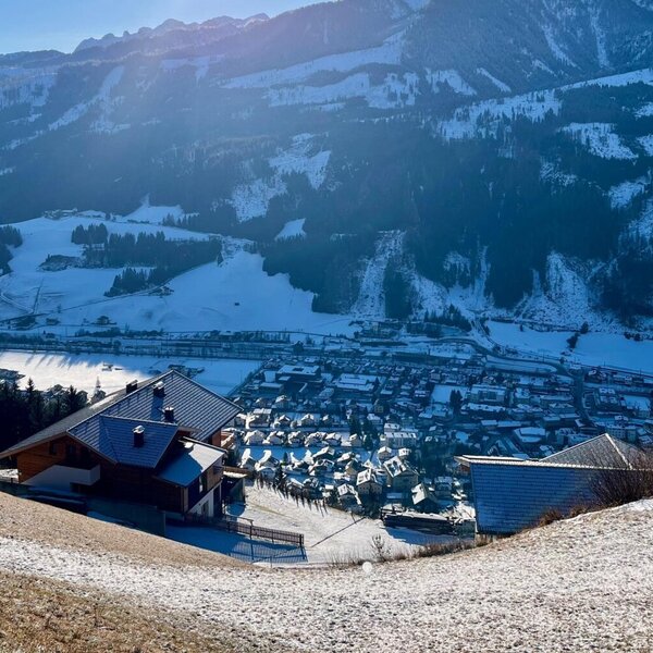 View from the farmhouse of the snow-covered mountain landscape and the valley with the village. View from the farmhouse of the snow-covered mountain landscape and the valley with the village.
