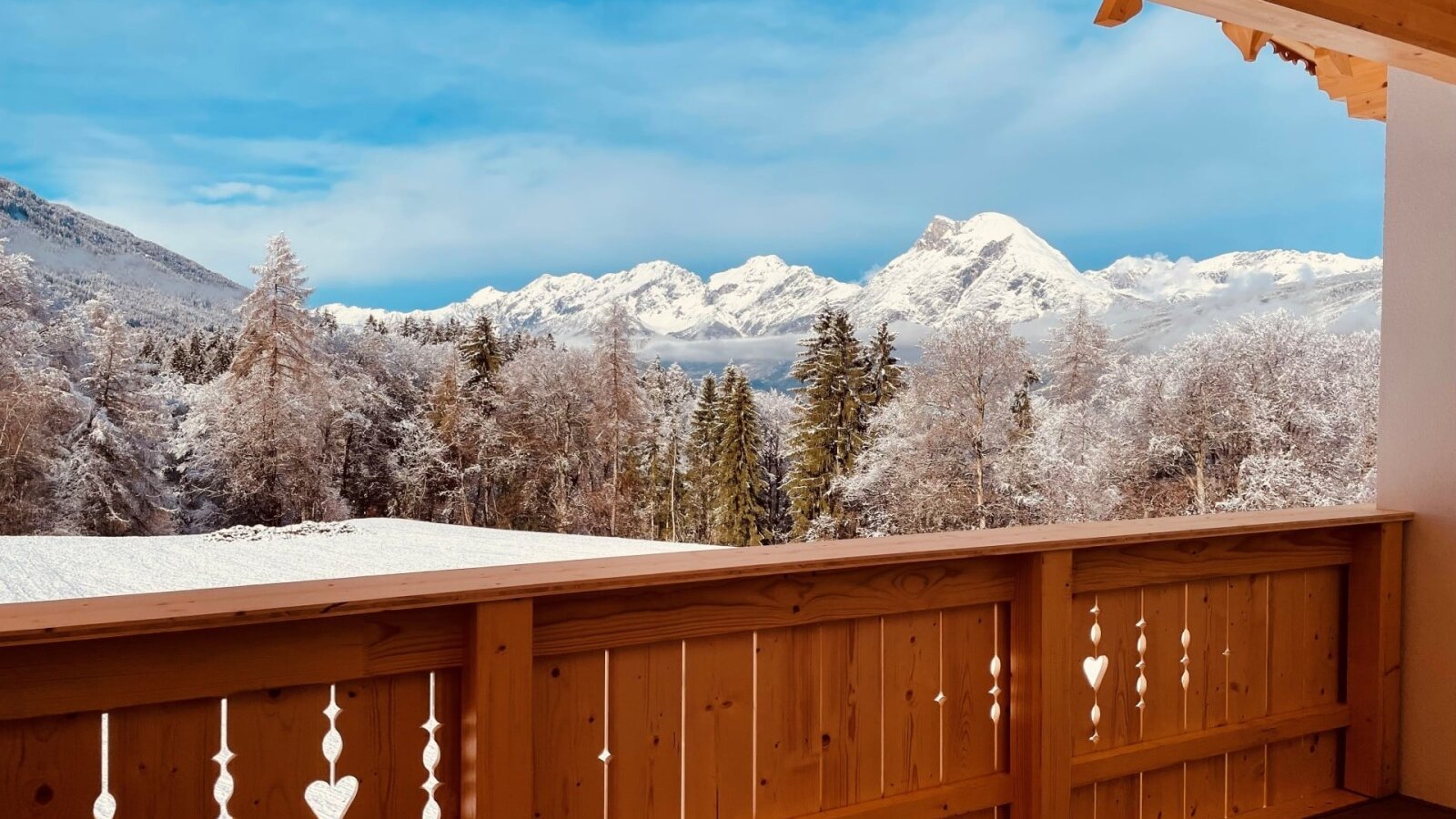 The apartment's balcony offers a picturesque view of snow-covered forests and the winter mountain landscape.