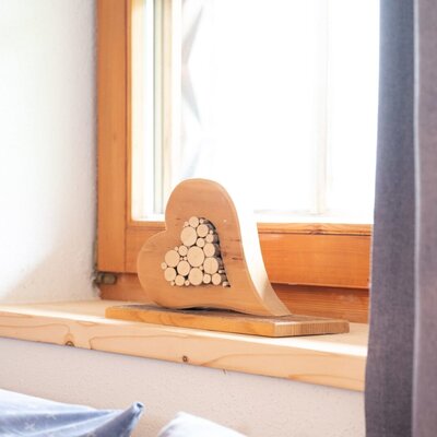 Wooden heart decoration on the windowsill of the Ap­par­te­ments.