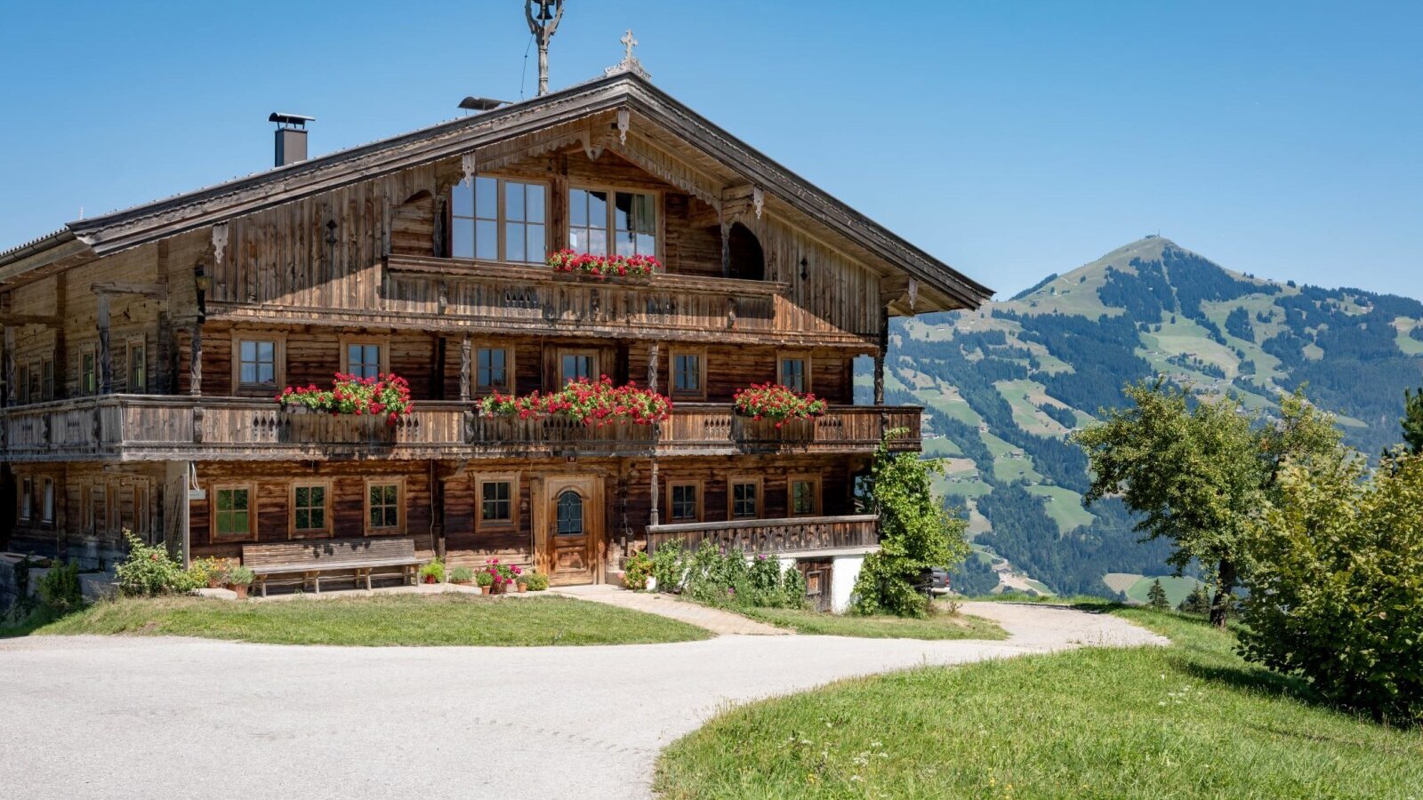 The apartments' idyllic farmhouse featuring flower-adorned balconies against a scenic mountain backdrop.