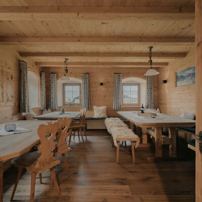 Dining area of the Ferienwohnung with wooden tables, benches, and chairs for shared meals.