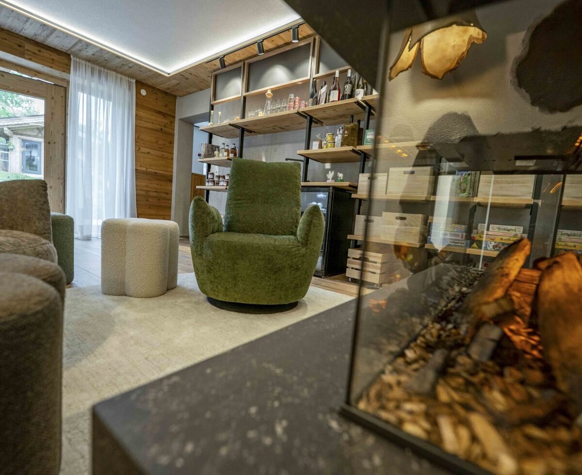The farmhouse's inviting lounge area featuring a plush armchair, a warm fireplace, and a selection of games.