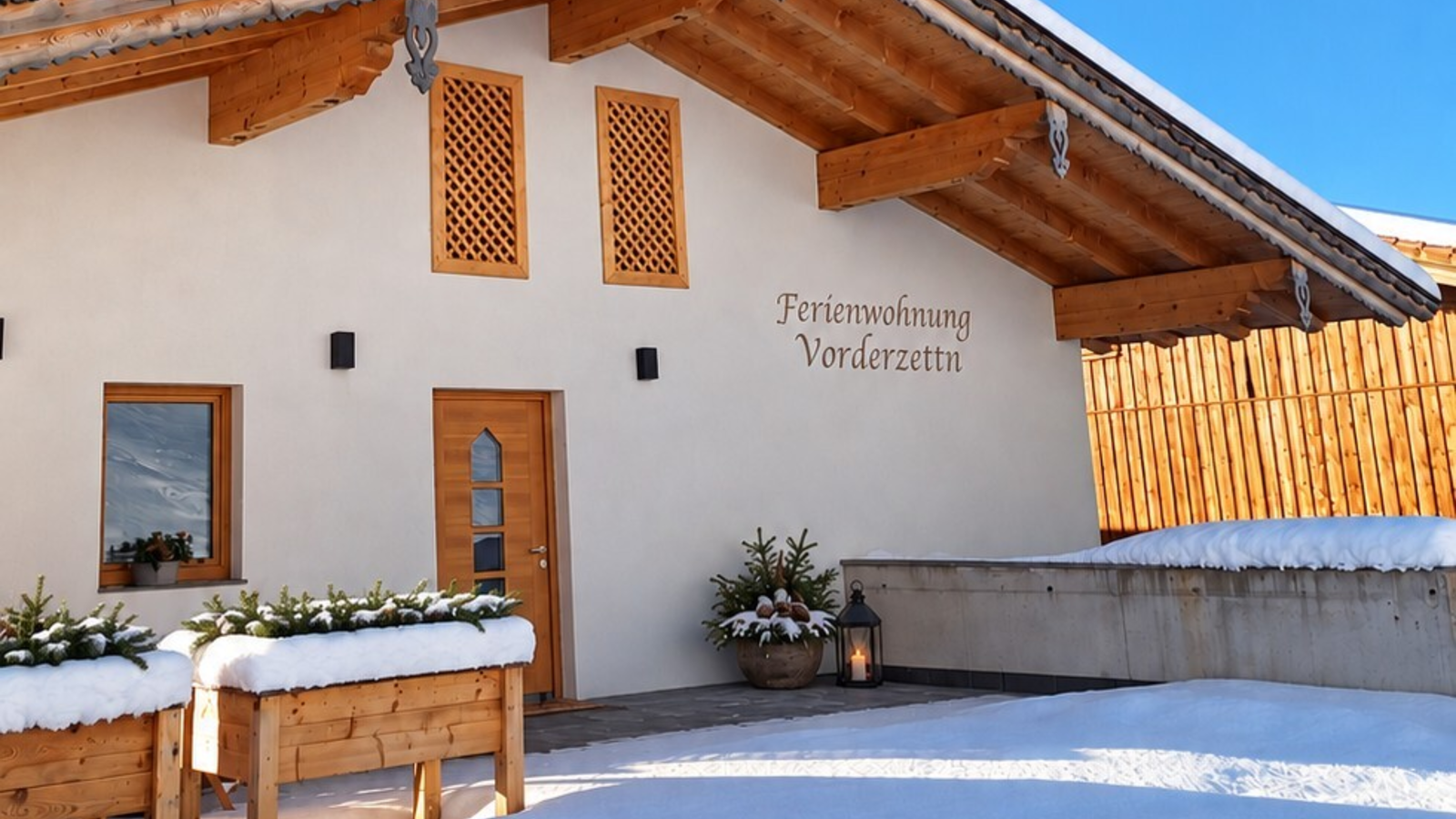 The farmhouse's inviting, snow-covered entrance area under a bright, clear blue sky.