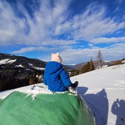 Winter fun at the farmhouse with a scenic view of the snow-covered mountain landscape.