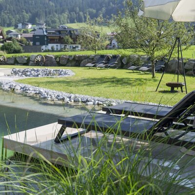 Guests at the Farm House can enjoy the natural swimming pond, sun loungers, and an outdoor seating area on the lawn with mountain views.