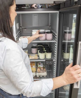Refrigerator at the Bauernhof with a selection of fresh farm products like yogurt and eggs available for purchase.