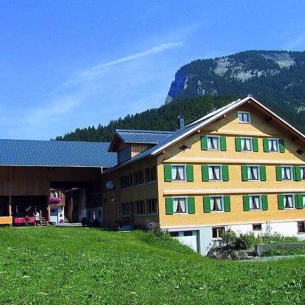 The exterior of the Rusch Farm House, including the main building and dairy barn, surrounded by green fields with mountains in the background. The exterior of the Rusch Farm House, including the main building and dairy barn, surrounded by green fields with mountains in the background.