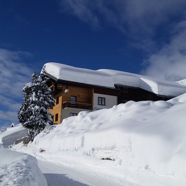 The Farm House exterior in a deep winter snow setting, with snow-covered trees and a bright blue sky. The Farm House exterior in a deep winter snow setting, with snow-covered trees and a bright blue sky.
