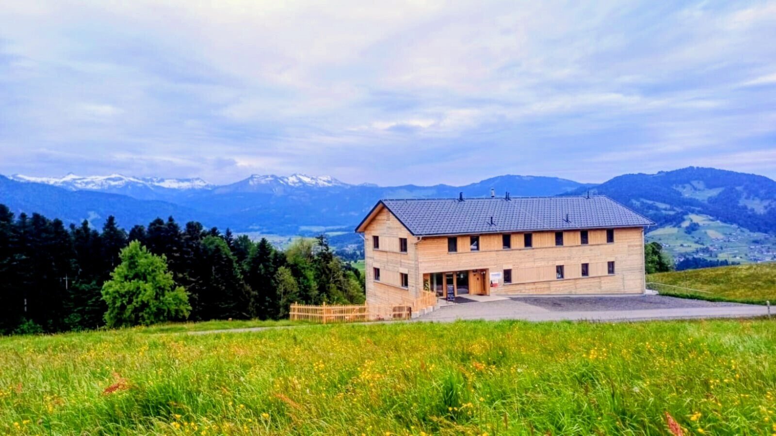 The newly built farmhouse in an idyllic, secluded location, surrounded by green mountain meadows with views of the Alps.