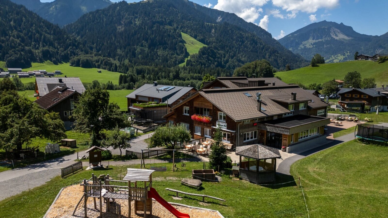 The welcoming farmhouse features a spacious playground set against the backdrop of the impressive Allgäu Alps.
