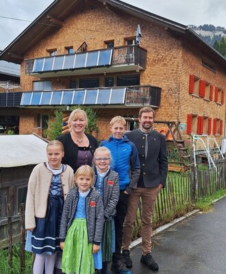 The host family in front of the farmhouse