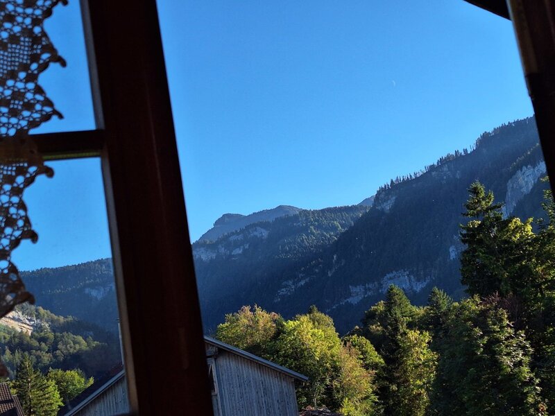 An idyllic view from the farmhouse window showcasing the surrounding mountains