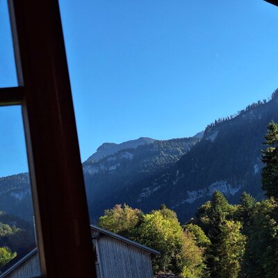 An idyllic view from the farmhouse window showcasing the surrounding mountains