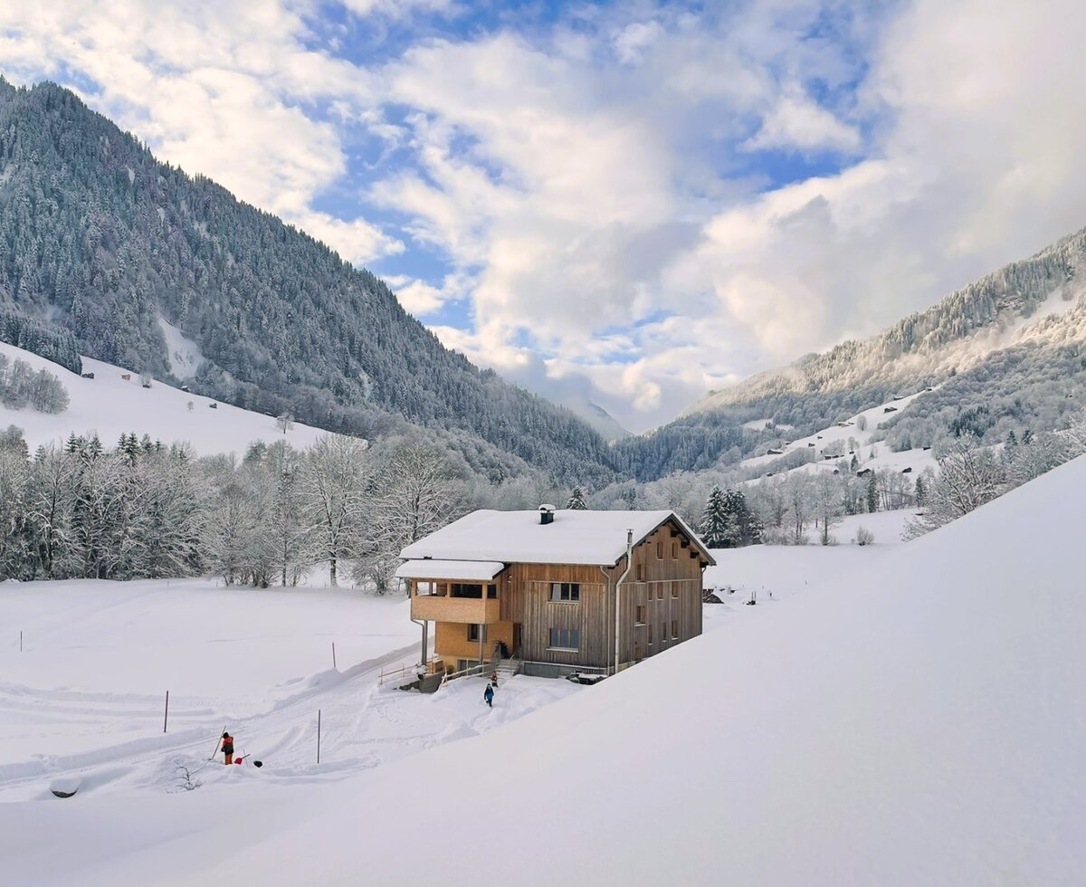 The building hosting the apartments, surrounded by an idyllic, snow-covered winter landscape.