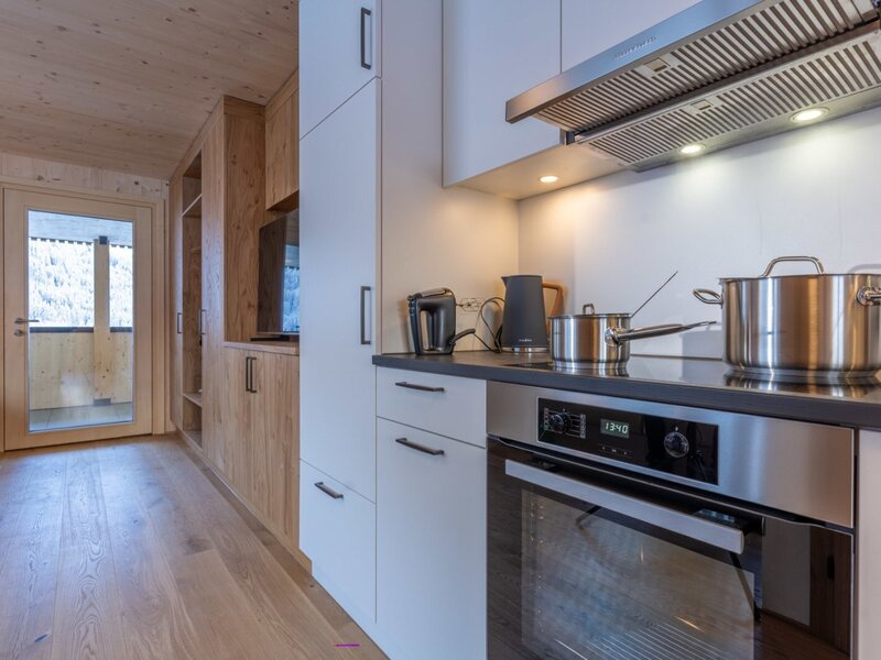 A modern, brightly lit kitchen in the apartment, featuring high-quality stainless steel appliances and stylish wooden cabinetry.