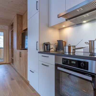 A modern, brightly lit kitchen in the apartment, featuring high-quality stainless steel appliances and stylish wooden cabinetry.