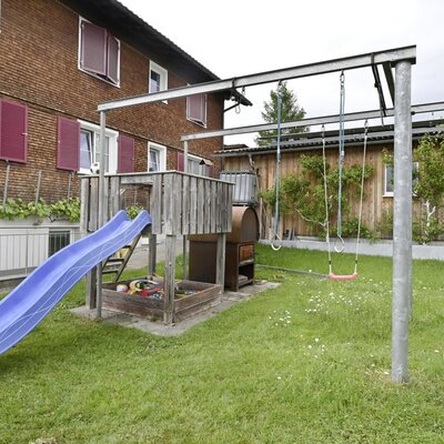The farmhouse's children's playground, featuring a slide, sandbox, and swings.