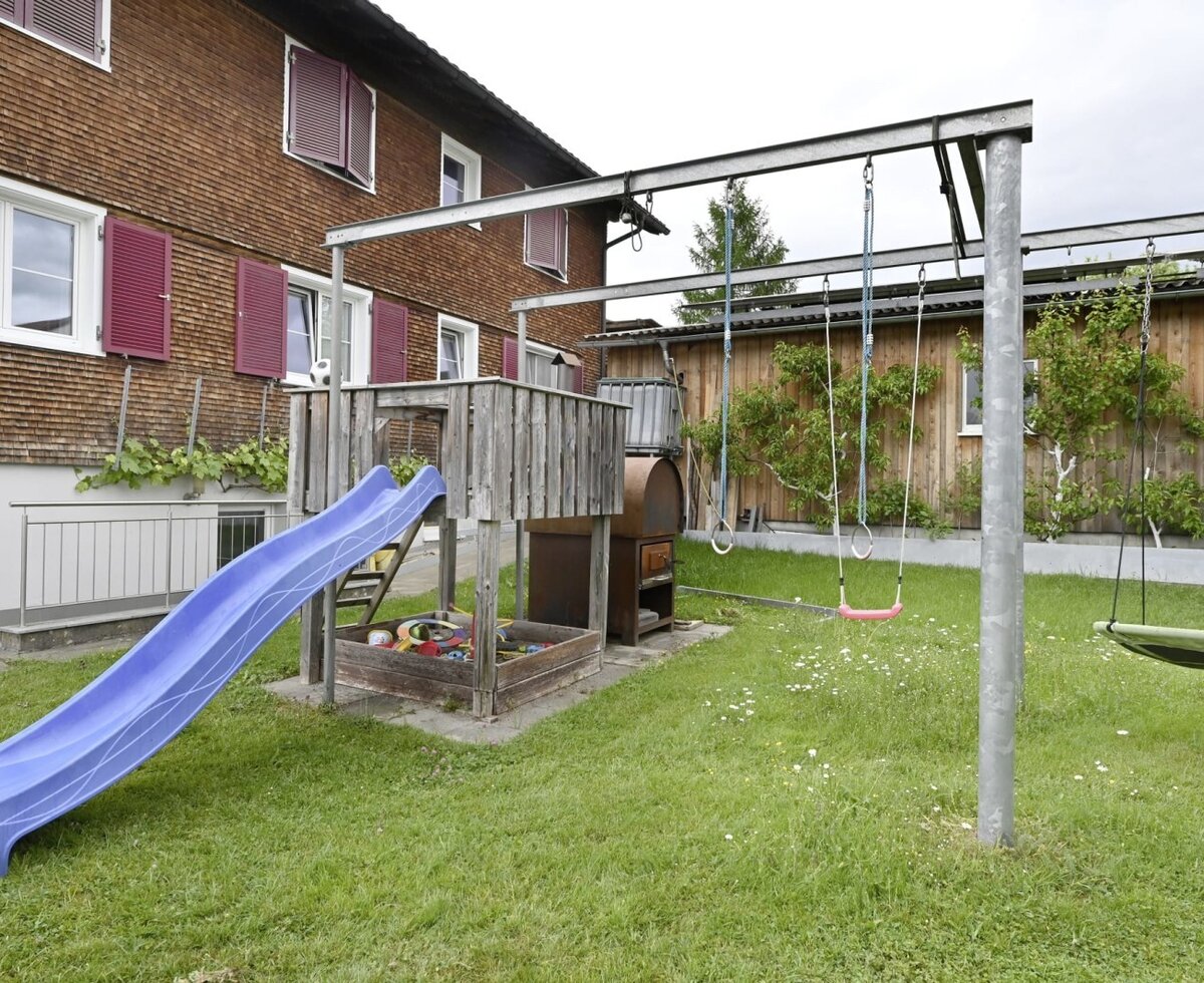 The farmhouse's children's playground, featuring a slide, sandbox, and swings.