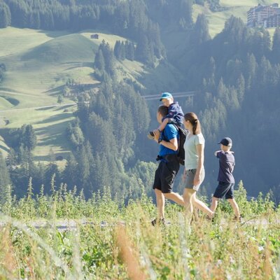 Guests with children enjoying a walk through the mountainous landscape near the Farm House.