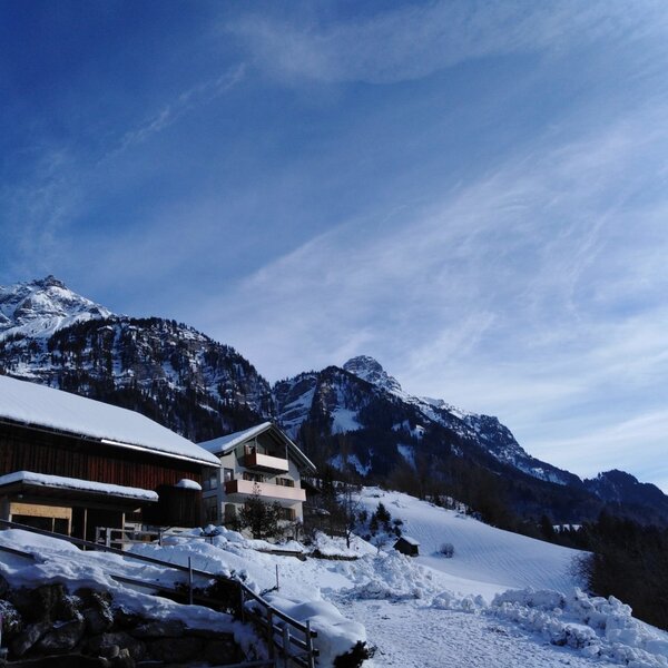 The Farm House buildings nestled in a snow-covered mountain landscape.
