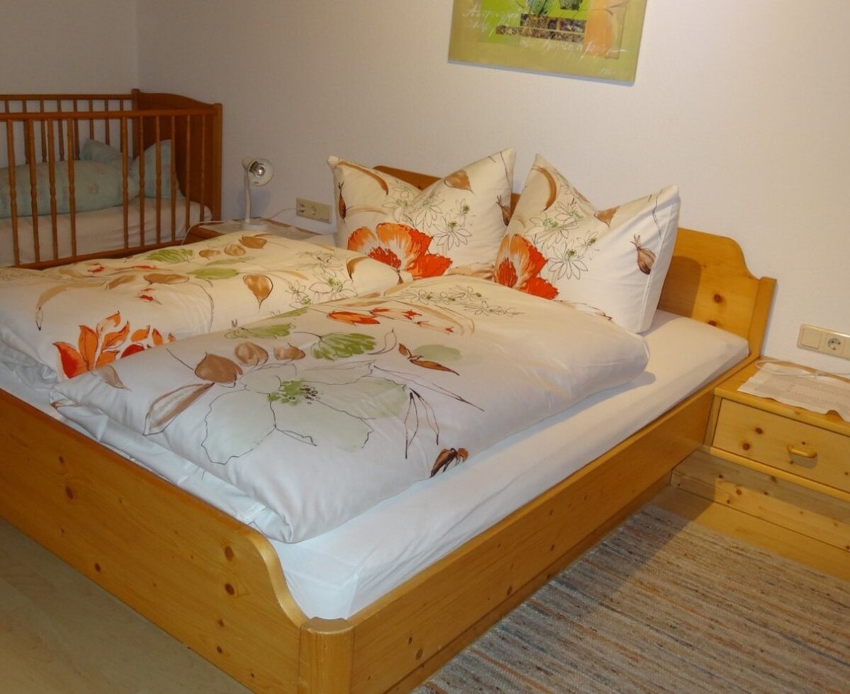 Bedroom with baby cot and bunk bed.