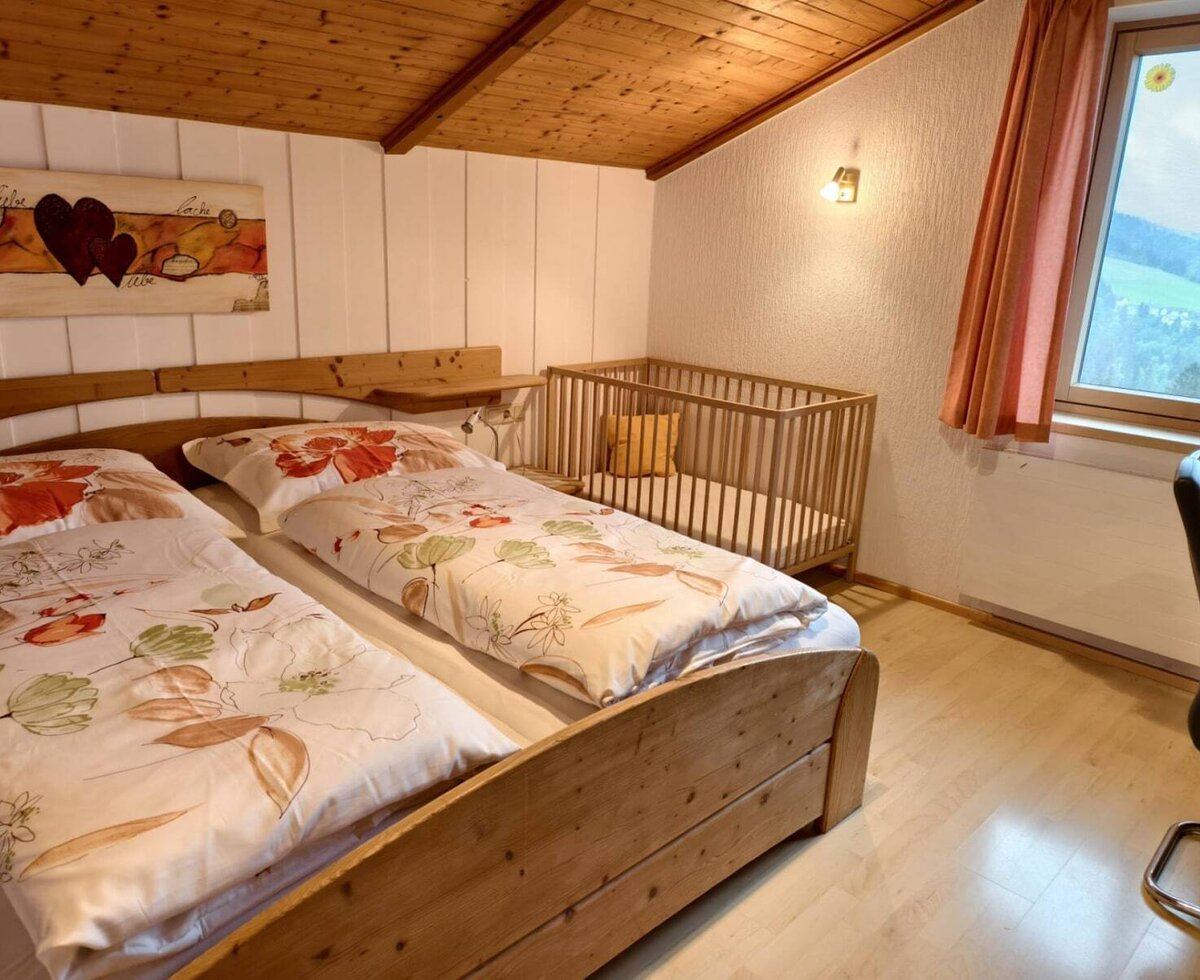 bedroom, a double bed, a wooden crib, and scenic countryside views.